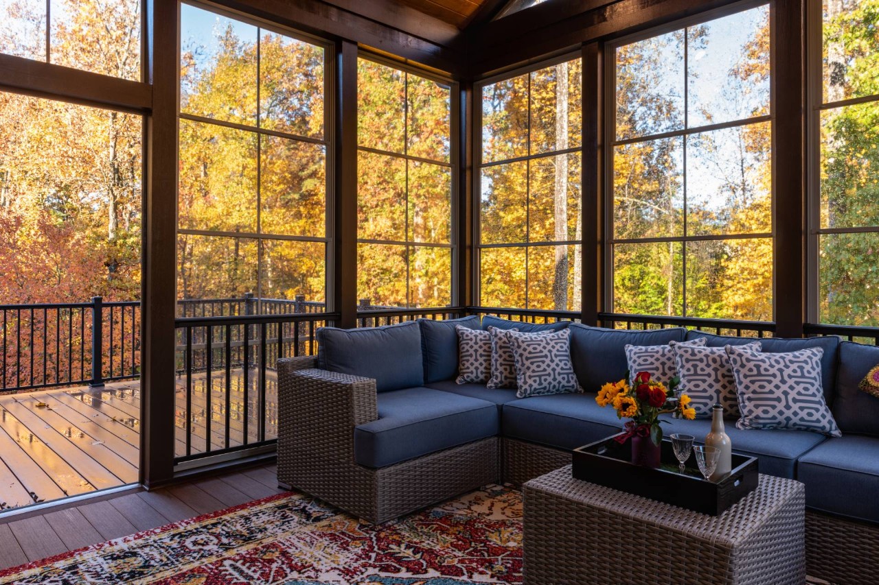 A well-decorated sunroom with stunning fall views and large windows without energy-efficient window treatments at Walls & Windows near Bellingham, WA