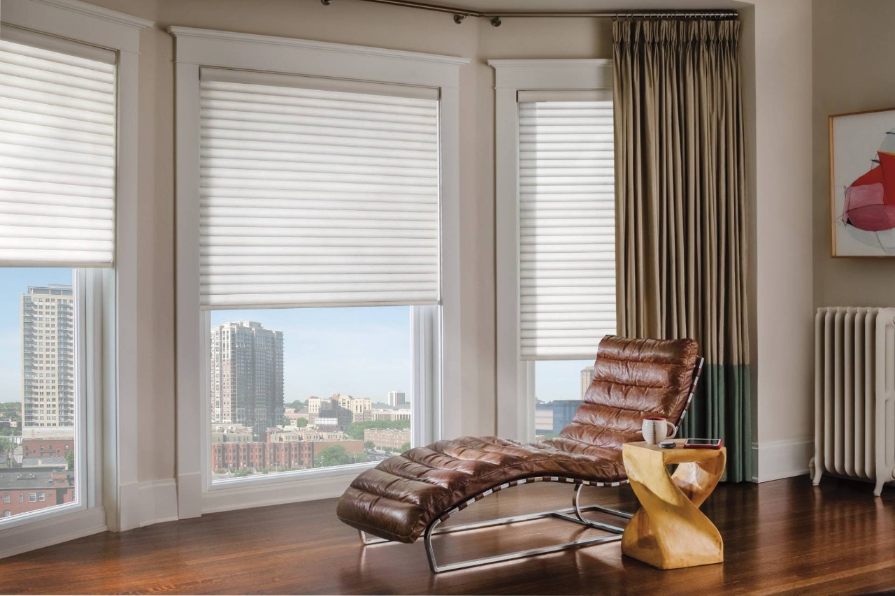 Hunter Douglas Sonnette® Roller Shades decorating a modern home living room with a leather lounge chair at Walls & Windows near Bellingham, WA