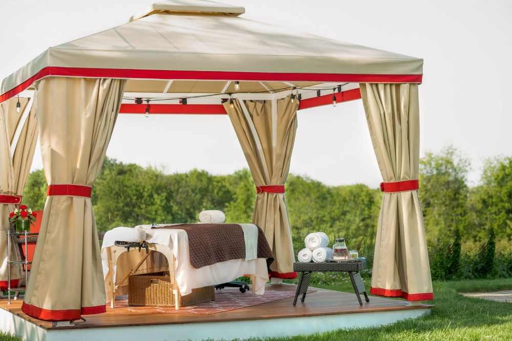 A beige and red SummerSpace® Open Air Cabana with a massage station near Bellingham, Washington (WA)