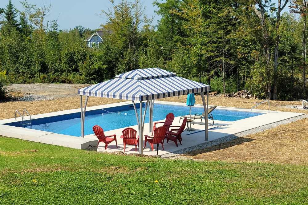 A blue and white striped SummerSpace® Open Air Cabana by a pool near Bellingham, Washington (WA)
